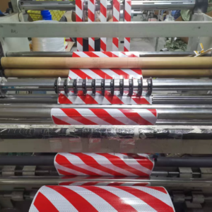 Diagonal stripe reflective tape moving through converting rollers