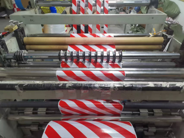 Diagonal stripe reflective tape moving through converting rollers
