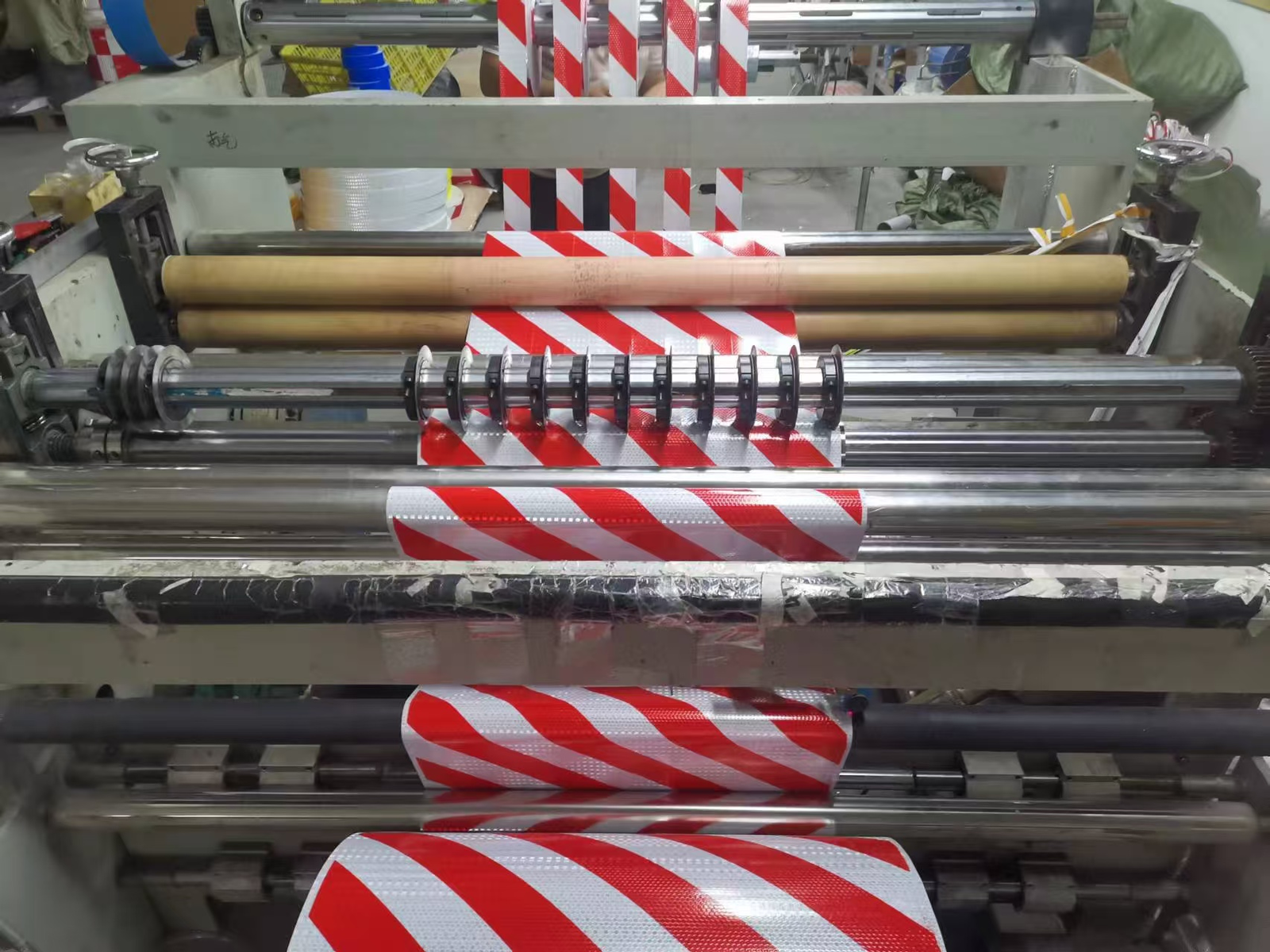 Diagonal stripe reflective tape moving through converting rollers