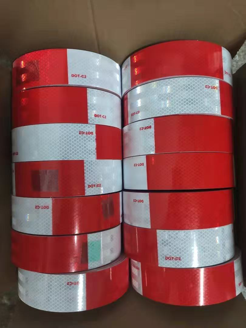 Red and white DOT-C2 reflective tape rolls packed in a carton