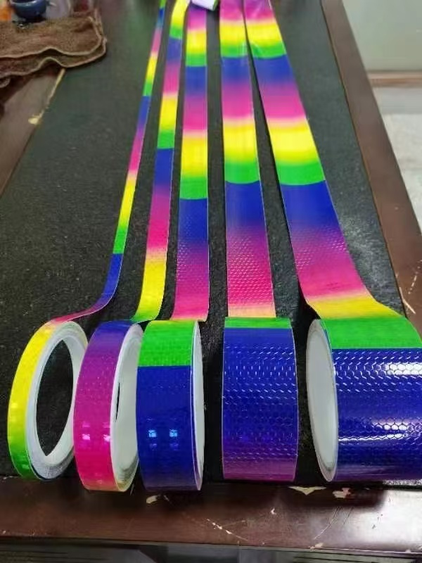Rainbow reflective tape rolls and strips on a worktable