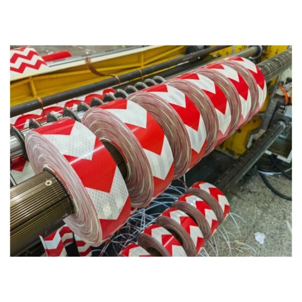 Red and white arrow tape rolls on processing equipment