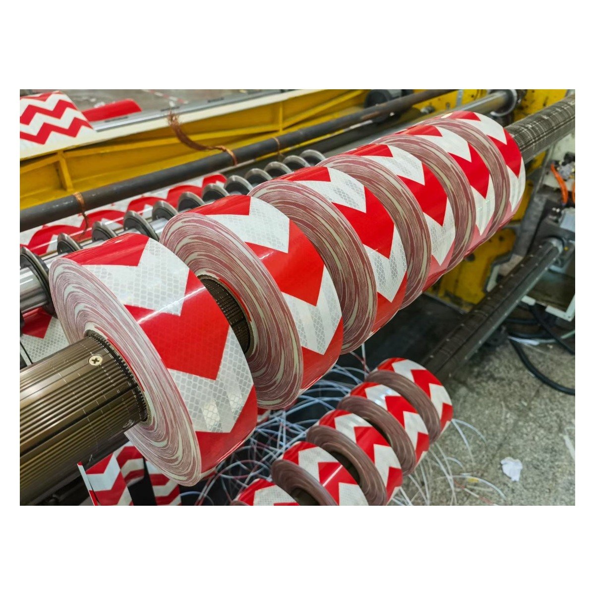 Red and white arrow tape rolls on processing equipment