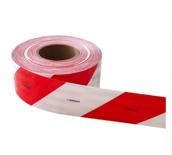 Red and white prismatic reflective tape partially unrolled