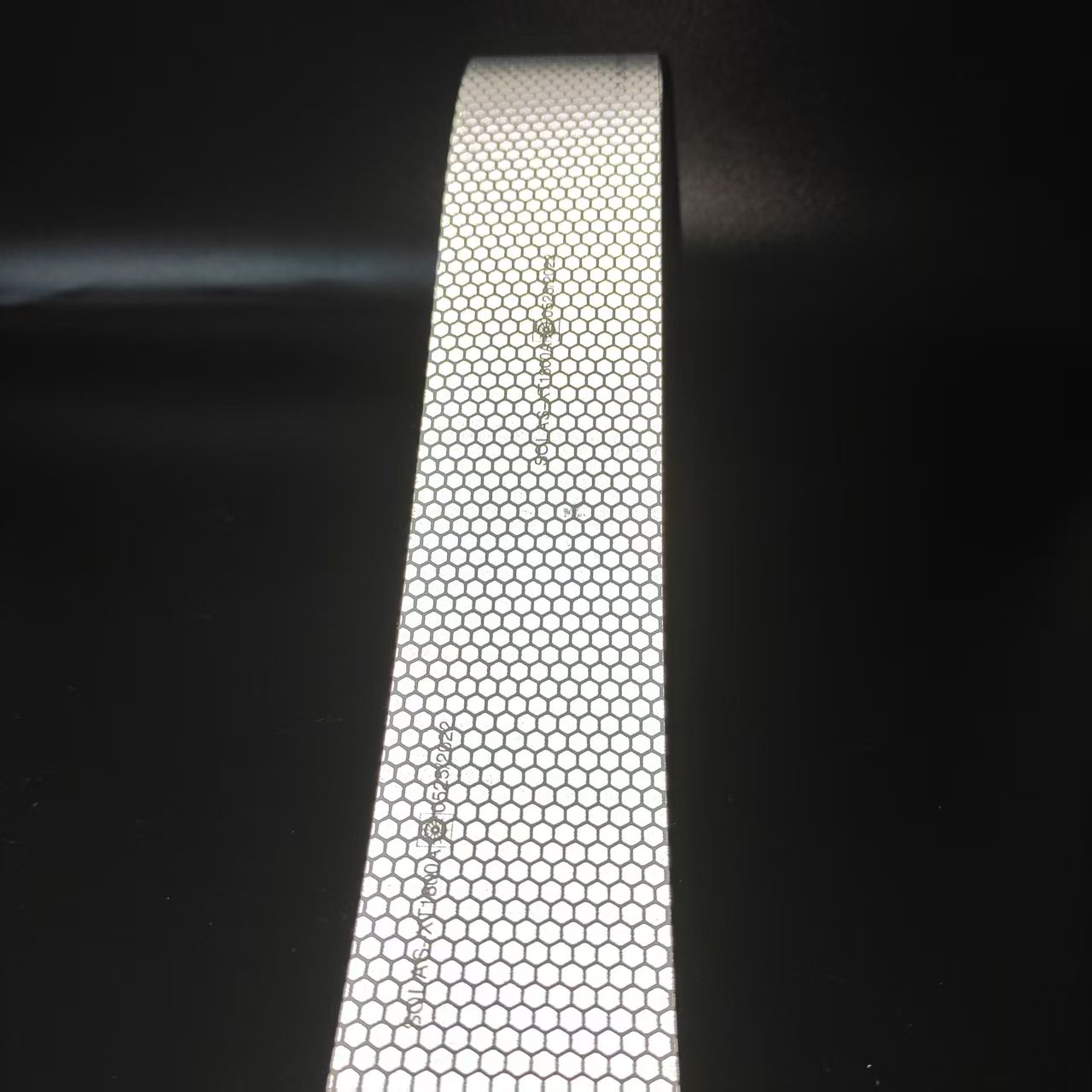Silver honeycomb reflective tape strip under direct illumination