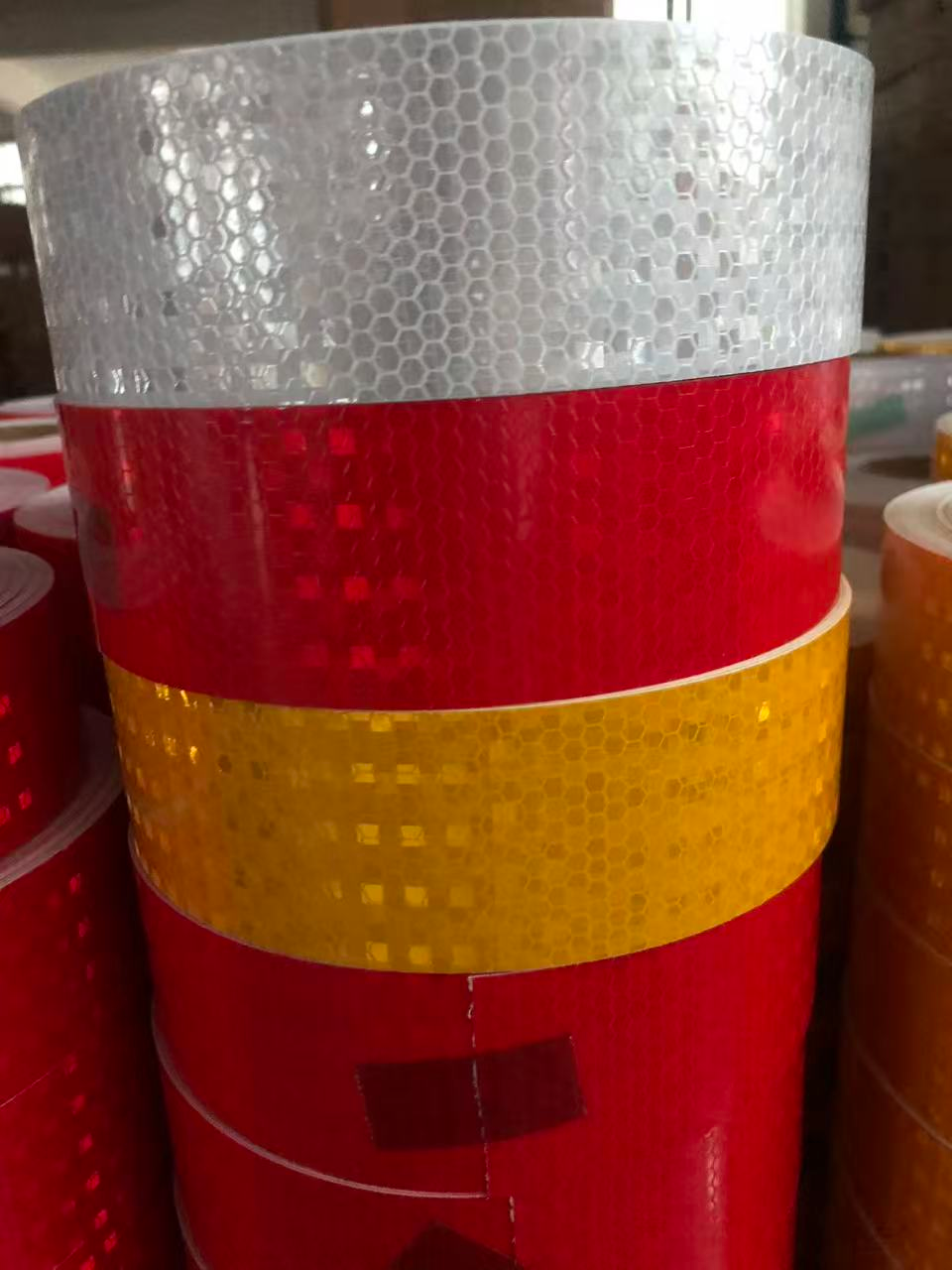 White red and yellow prismatic reflective tape rolls stacked together
