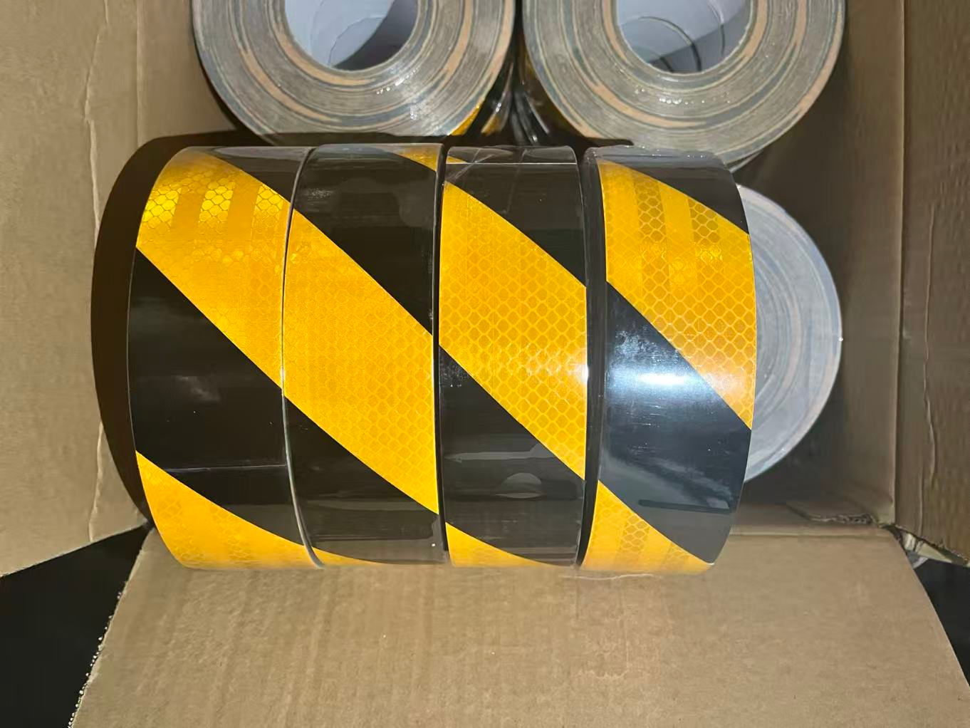 Yellow and black slant reflective tape rolls in carton