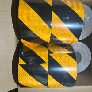 Stacked yellow and black slant stripe reflective tape rolls