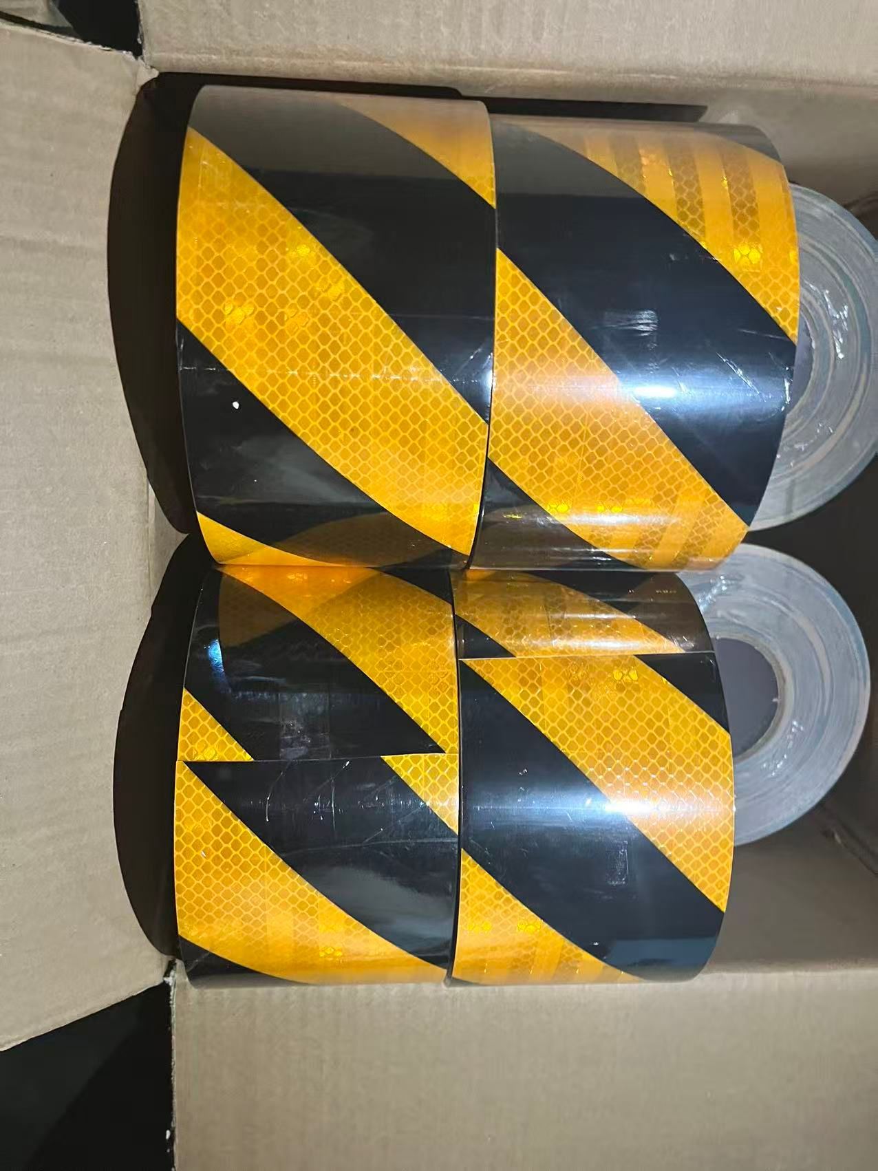Stacked yellow and black slant reflective tape rolls