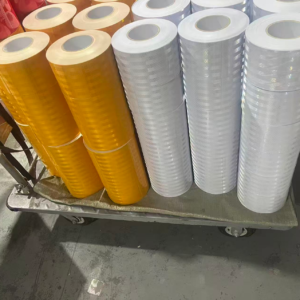 Yellow and white reflective warning tape rolls in production stock