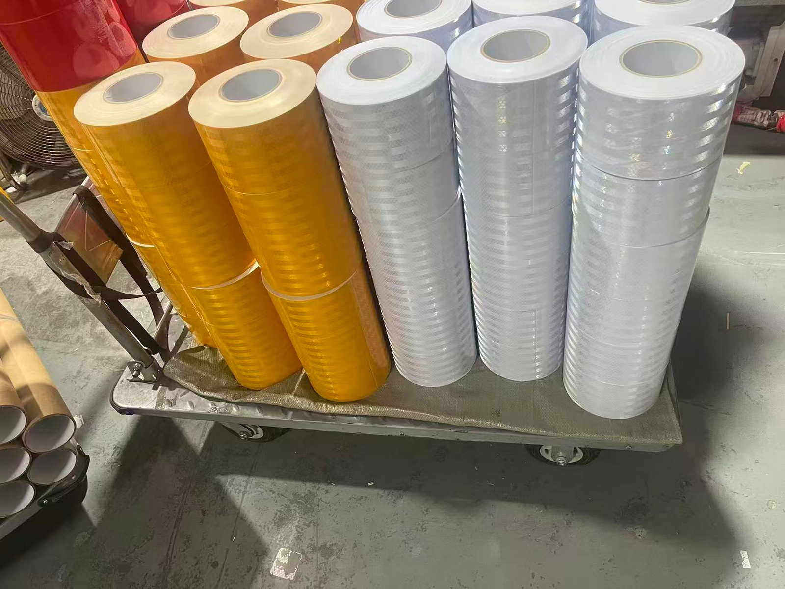 Yellow and white reflective warning tape rolls in production stock