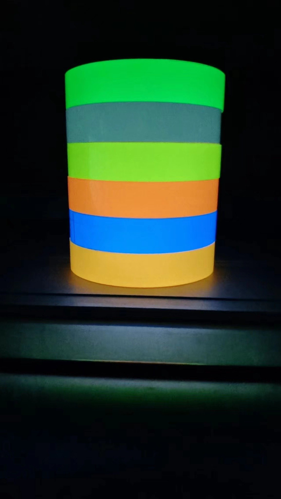 Stacked colored luminous tape samples shown against a dark background