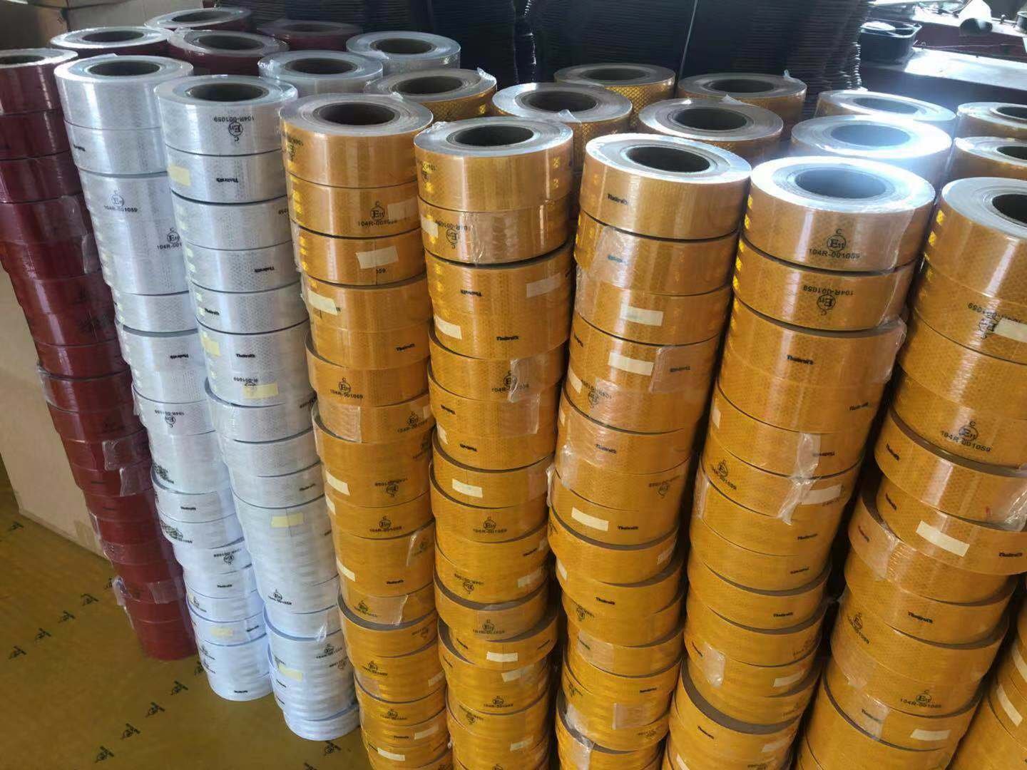 Packed white, yellow and red reflective tape rolls in the workshop