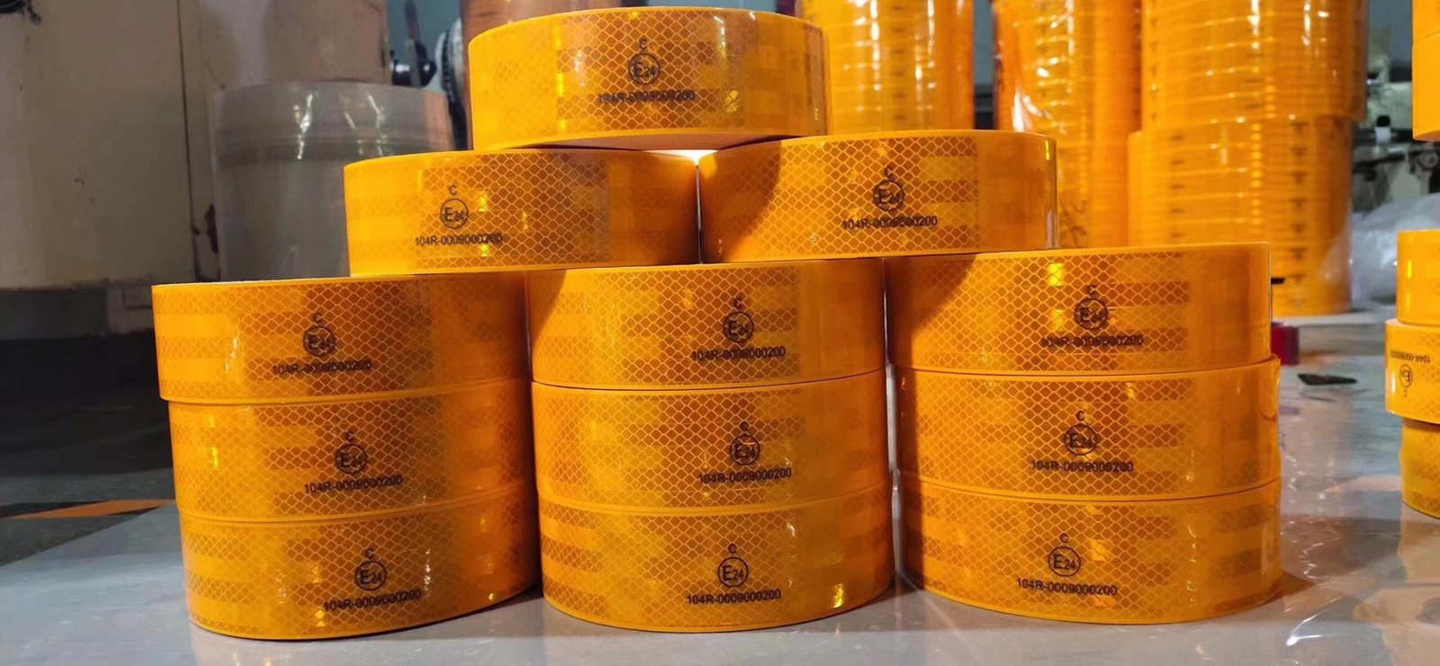 Stacked golden-yellow reflective tape rolls showing the prismatic pattern and printed markings