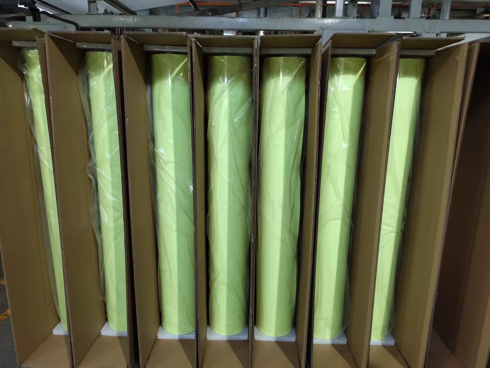 Photoluminescent film rolls individually wrapped and supported in cardboard packaging