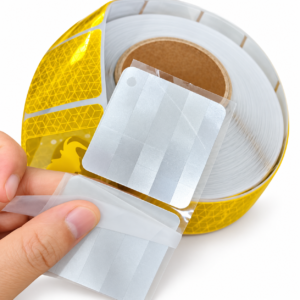 Close-up of the peeled release liner and backing on yellow elephant reflective tape