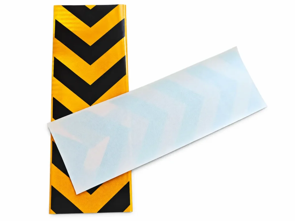 Yellow and black PET chevron sticker with the pale reverse side shown at an angle