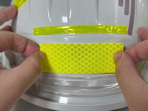 Fluorescent yellow reflective sticker positioned on a smooth curved sample surface