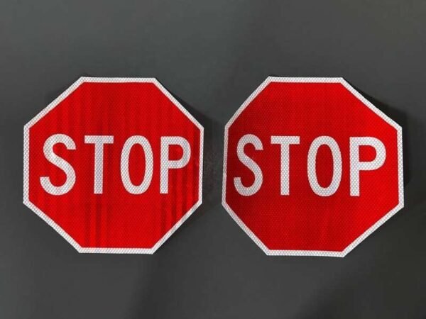 Two red and white octagonal STOP sign faces displayed side by side