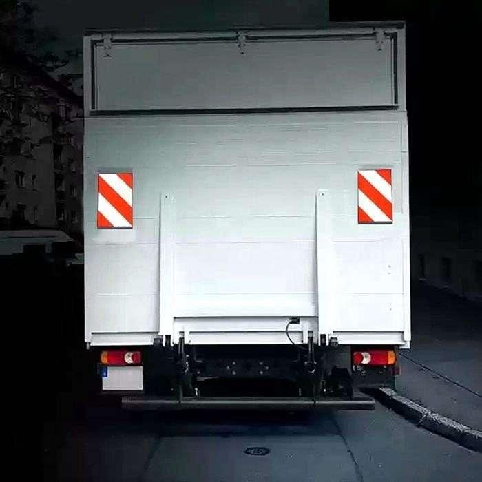 Red and white tail lift marking flags illustrated on the rear of a delivery truck