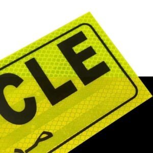Close-up of fluorescent yellow reflective LONG VEHICLE sticker surface