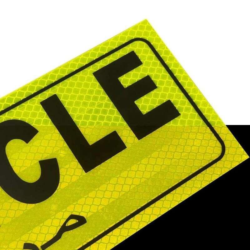 Close-up of fluorescent yellow reflective LONG VEHICLE sticker surface