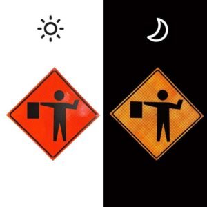 Orange flagger warning sign shown in daylight and under nighttime illumination