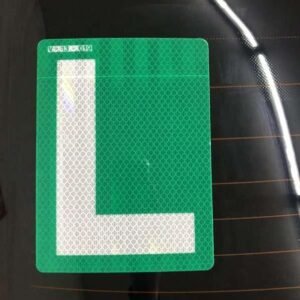Green and white reflective L sticker displayed on a vehicle rear window