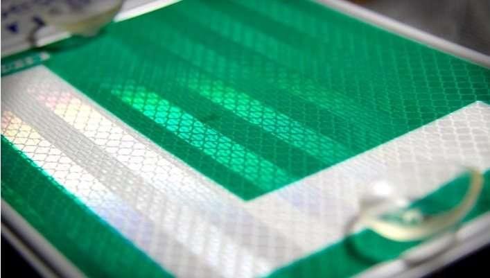 Close-up of green and white reflective L sticker material