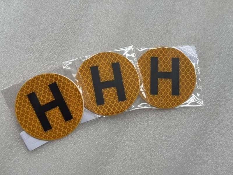 Yellow reflective H stickers in individual clear sleeves