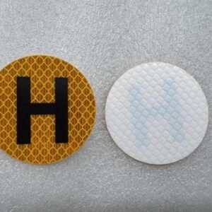 Front and white reverse of round yellow reflective H sticker