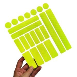 Yellow reflective sticker sheet held to show mixed shapes