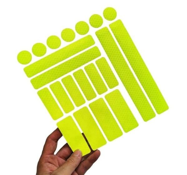 Yellow reflective sticker sheet held to show mixed shapes
