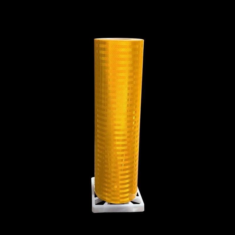 Yellow acrylic reflective sheeting roll photographed against a dark background
