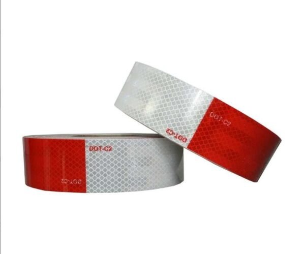 Two red and white prismatic vehicle tape rolls showing printed markings