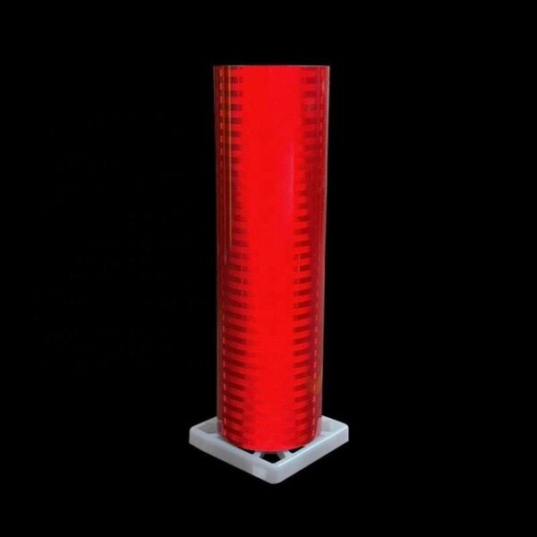 Red prismatic reflective sheeting roll against a dark background