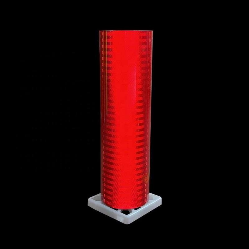 Red prismatic reflective sheeting roll against a dark background