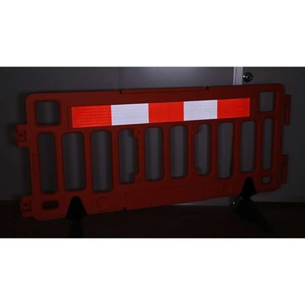 Red and white reflective strip installed across the upper panel of a barrier