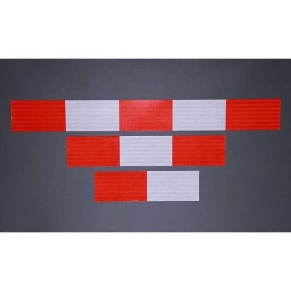 Three lengths of red and white reflective barrier strips