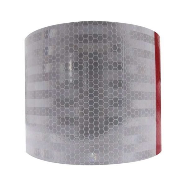 White reflective face of a wide red and white tape roll in ambient light