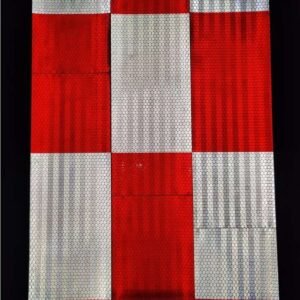 Alternating red and white reflective barrier sections under directed light