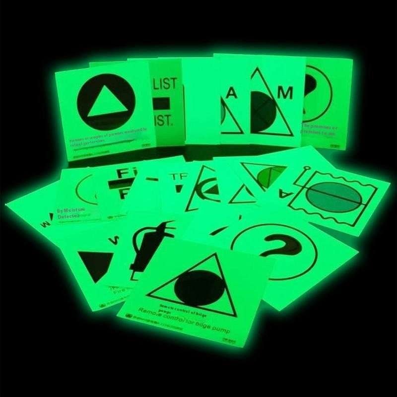 Custom printed photoluminescent symbol samples glowing in darkness
